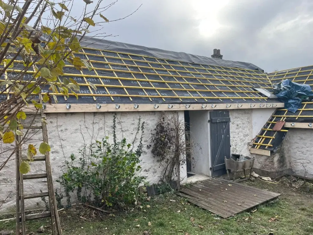 Écran de sous-toiture noir et liteaux jaunes sur toiture